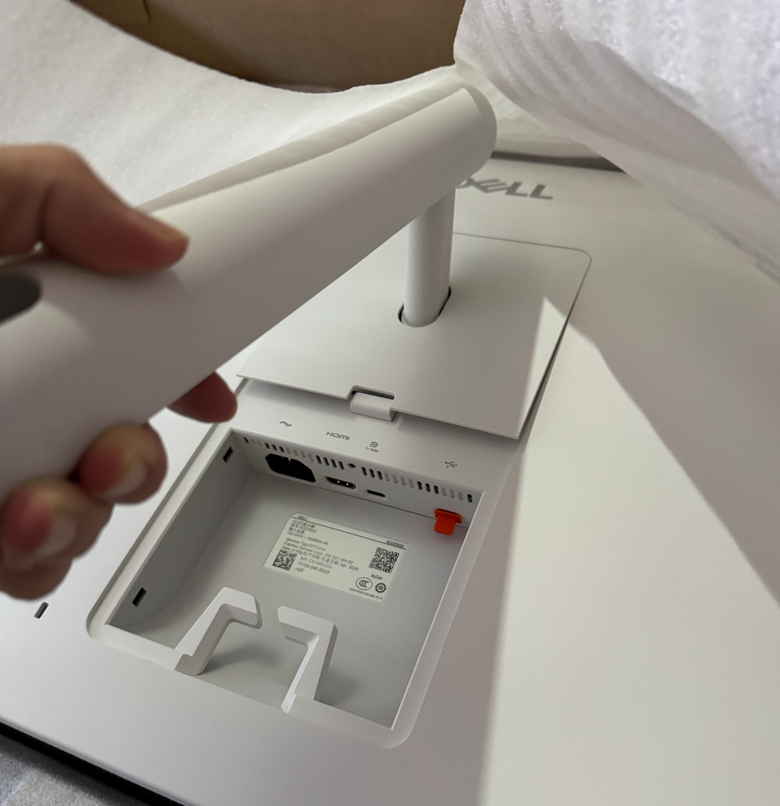 箱の中にある大型PCモニターにスタンドを取り付けている写真